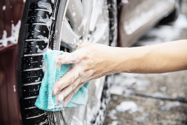 Mann waschen Auto mit Shampoo