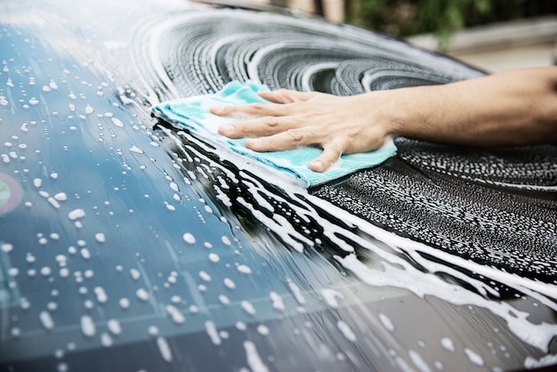 Kostenloses Foto mann waschen auto mit shampoo
