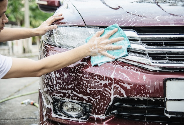 Mann waschen Auto mit Shampoo