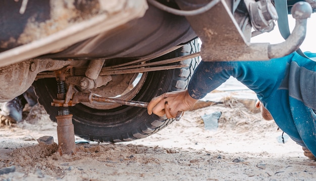 Mann wirft auf einen Wagenheber 4x4 aus dem Straßenverkehr