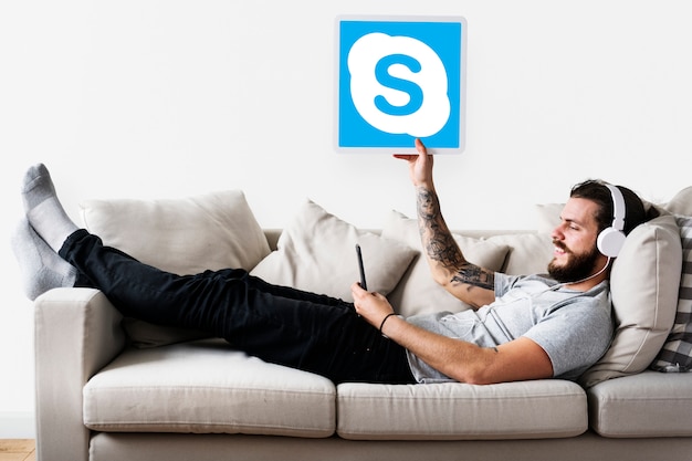 Mann zeigt ein Skype-Symbol