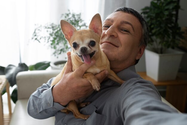 Mann zu Hause, der ein Selfie mit seinem Hund macht
