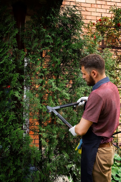 Kostenloses Foto manndiener, der sich um den garten kümmert