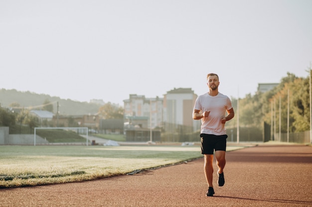 Mannsportler, der morgens im stadion joggt