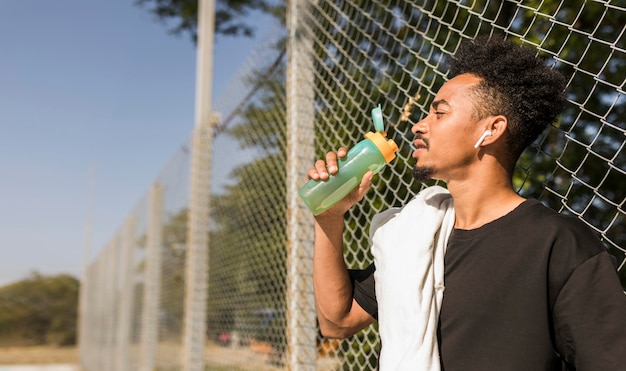 Kostenloses Foto manntrinkwasser nach einem basketballspiel