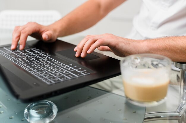 Mans Hände drücken die Tasten des Laptops