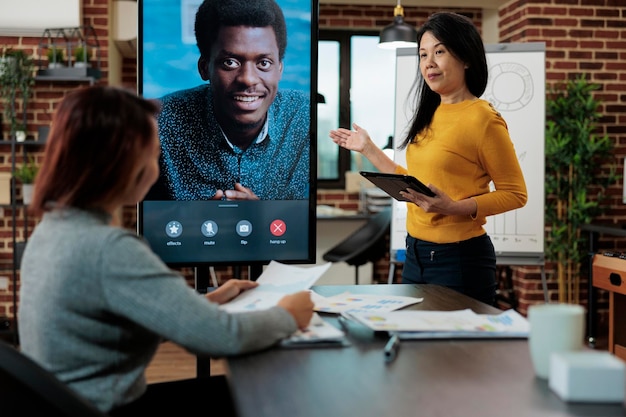 Marketing-Team bespricht Unternehmensstrategie mit Remote-Manager während Online-Videoanruf-Konferenzsitzung im Startup-Büro. Geschäftsleute, die an Partnerschaftsprojekten arbeiten. Telefonkonferenz