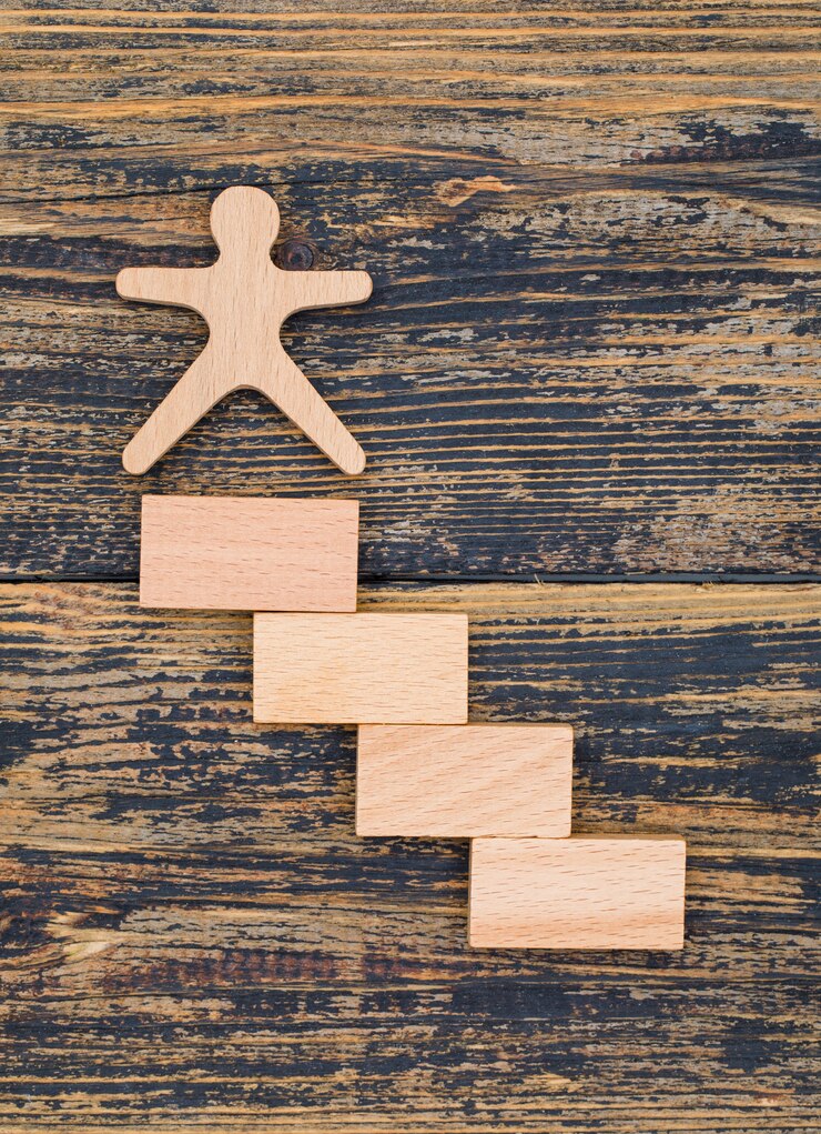 Kostenlose Foto marketingkonzept mit holzfigur und blöcken auf holzhintergrund flach legen.
