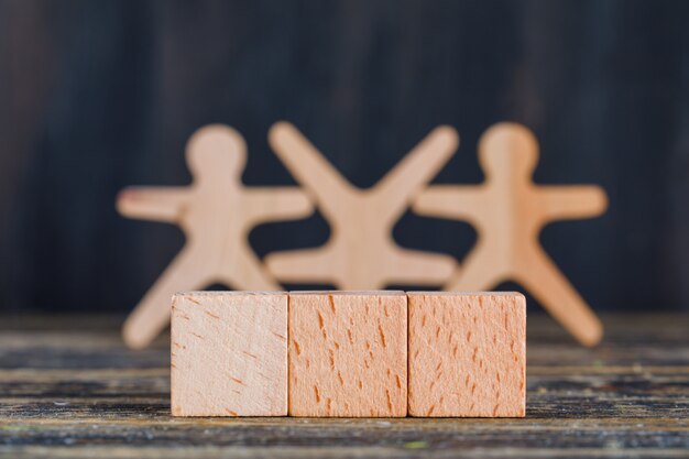 Marketingkonzept mit Holzfiguren, Würfeln auf Holz- und Schmutzhintergrund-Seitenansicht.