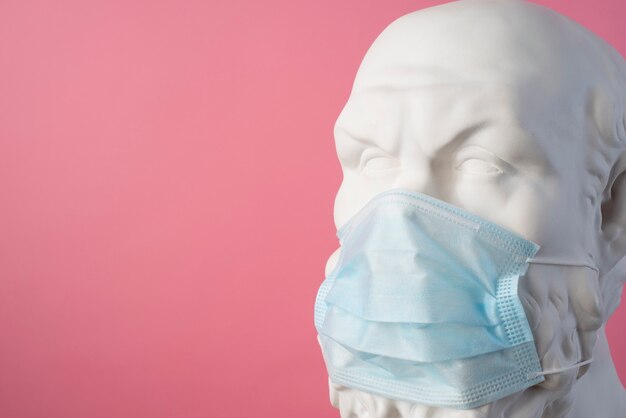 Marmorskulptur einer historischen Figur mit medizinischer Maske