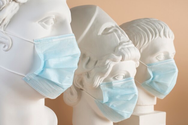 Marmorskulpturen historischer Figuren mit medizinischen Masken