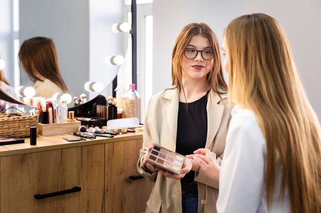 Maskenbildner, der der Frau Palette zeigt