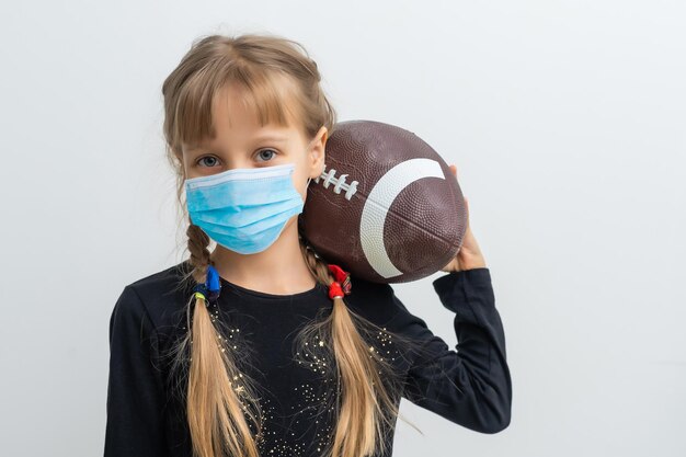 Maskiertes Kind - Schutz vor Influenzavirus. Kleines kaukasisches Mädchen, das eine Maske trägt, um pm2.5 zu schützen. Biologische Waffen. Baby auf grauem Hintergrund mit Kopienraum. Epidemie Pandemie.