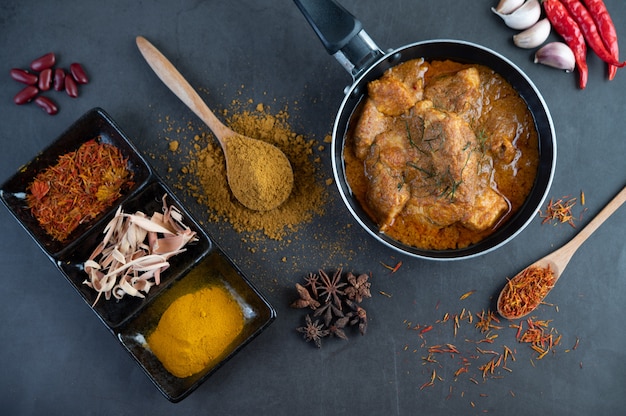 Massaman Curry in einer Pfanne mit Gewürzen auf dem Zementboden