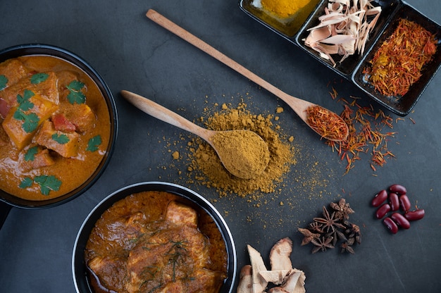 Massaman Curry in einer Pfanne mit Gewürzen auf dem Zementboden