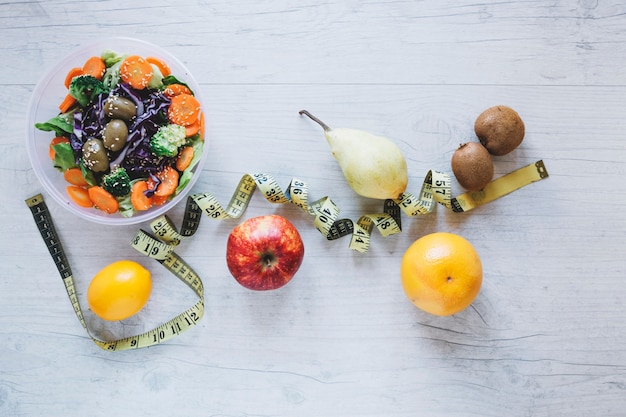 Maßband zwischen Früchten und Salat