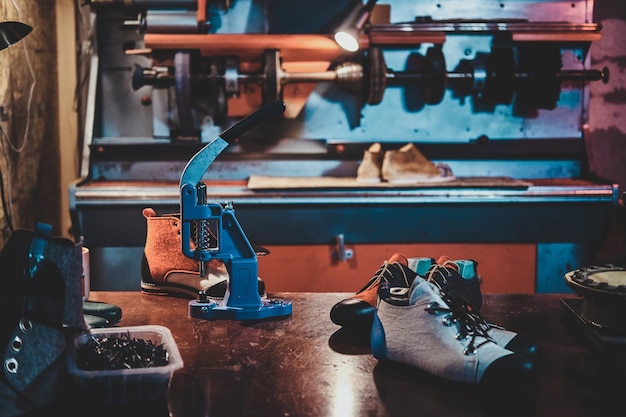 Maßgeschneiderte handgefertigte Schuhe auf dem Tisch am Arbeitsplatz des geschäftigen Schuhmeisters.