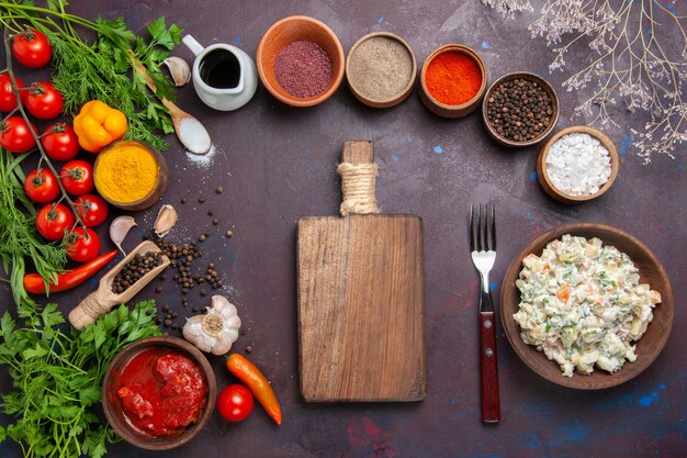 Mayyonaise-Salat von oben mit Gemüse und Gewürzen auf dunklem Raum