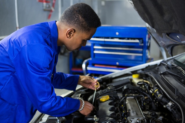 Mechaniker Überprüfung der Ölstand in einem Automotor