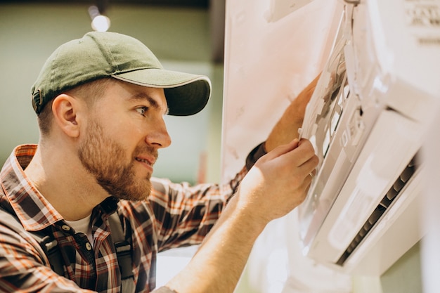 Kostenloses Foto mechaniker, der den service der klimaanlage durchführt