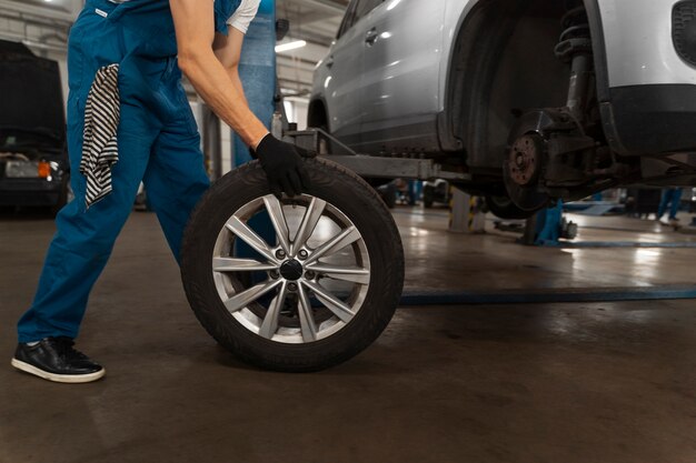 Mechaniker, der in der Werkstatt an einem Auto arbeitet