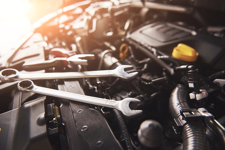 Kostenlose Foto mechaniker handprüfung und reparatur eines kaputten autos in der autowerkstatt.