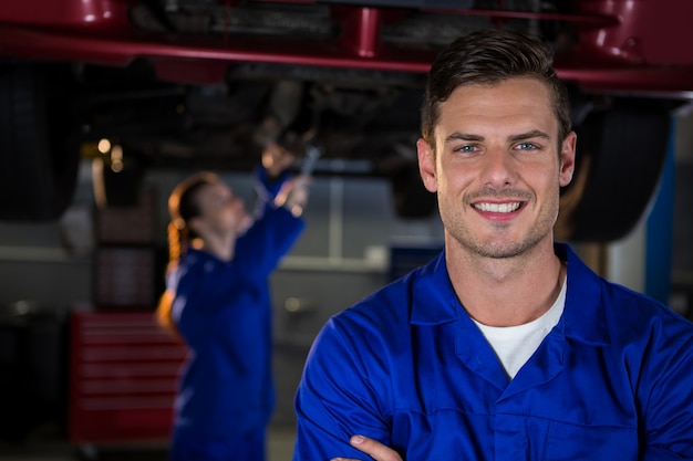 Kostenloses Foto mechaniker stehen bei reparatur garage