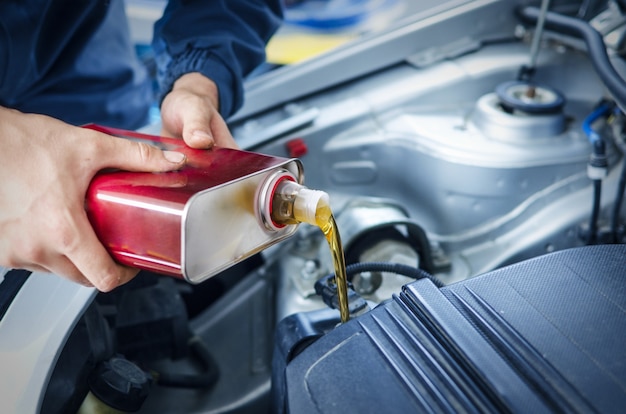 Mechaniker wechselt das Motoröl am Fahrzeug
