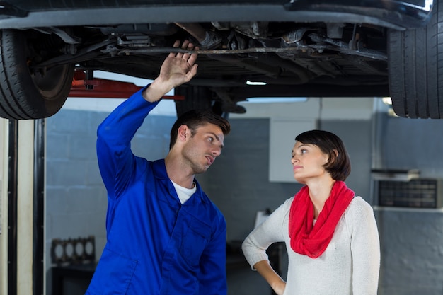 Mechaniker zeigt Kunde das Problem mit dem Auto