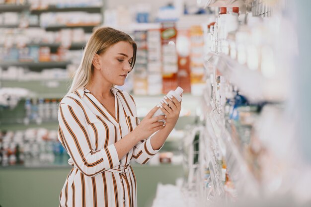 Medizin, Pharmazie, Gesundheitswesen und Personenkonzept. Frau, die Medikamente aus dem Regal nimmt. Käufer.