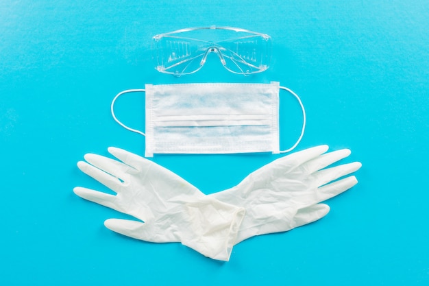 Medizinische Handschuhe von oben mit Maske und Brille. horizontal