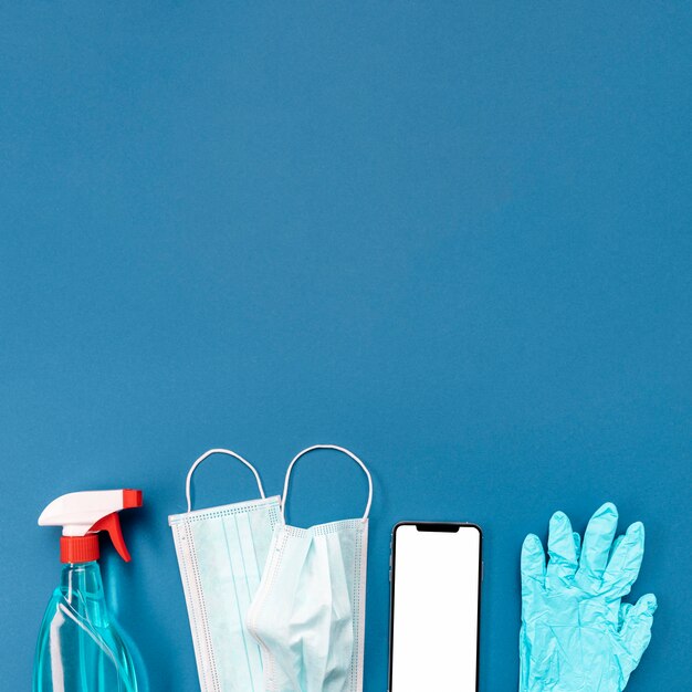 Medizinische Maske und Handschuhe von oben mit leerem Telefon