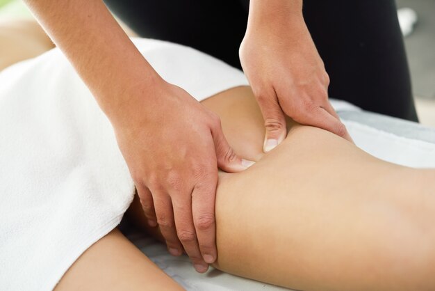 Medizinische Massage am Bein in einer Physiotherapie-Mitte.