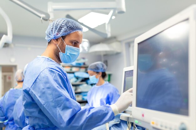 Medizinisches Beatmungsgerät, das vom Anästhesisten mit einem Monitor im Operationssaal überwacht wird