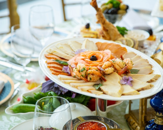 Meeresfrüchteteller mit gebratenen Garnelen, Räucherlachs und anderen Fischscheiben