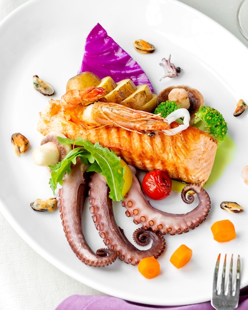 Meeresfrüchteteller mit gegrillten Lachs-Oktopus-Muscheln, Garnelen, Pilzen und Kartoffeln