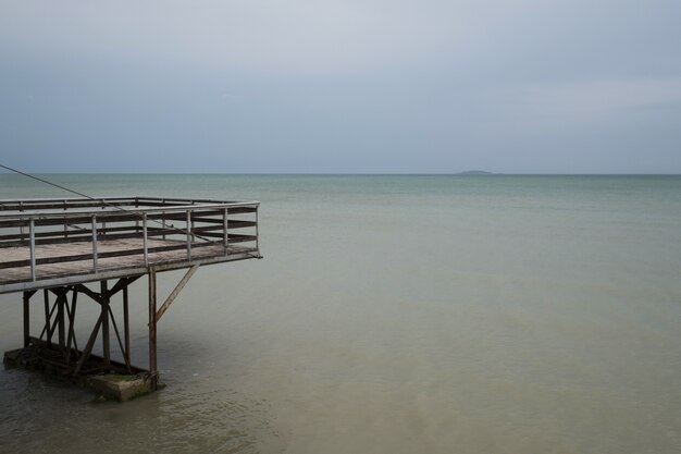 Meerwasser und blauer Himmel zusammen mit hölzernem Pier