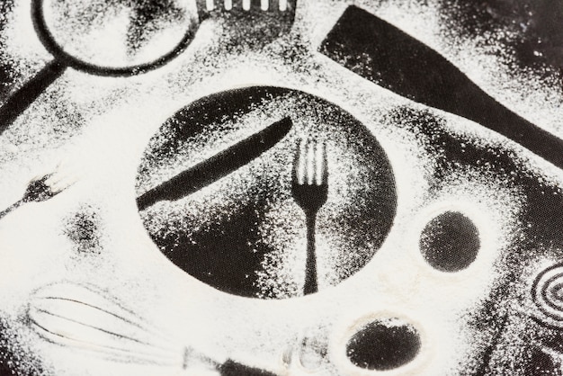 Mehl auf schwarzem Hintergrund mit Formen von Küchenelementen