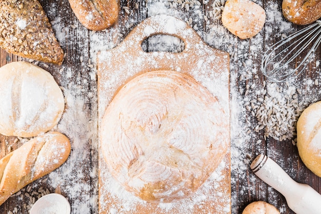 Mehl breitete sich über den runden Brötchen und Brot über den Tisch aus