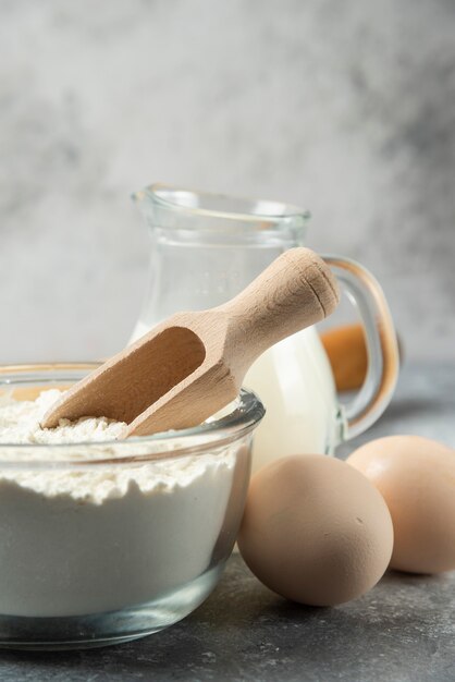 Mehl, Eier und Milch auf Marmor schließen.