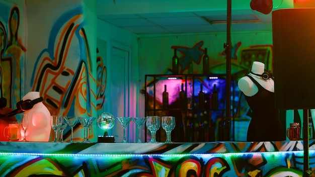 Kostenloses Foto mehrere alkoholische getränke an der bar bei einer underground-funky-party, leere tanzfläche im nachtclub. diskothek, vorbereitet für tanzveranstaltungen mit dj-mixing-auftritt und live-musikshow.