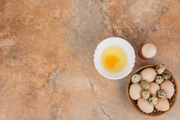 Mehrere Eier mit rohem Ei auf dem weißen Teller in der Marmoroberfläche