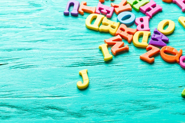 Mehrere farbige Buchstaben auf Holztisch