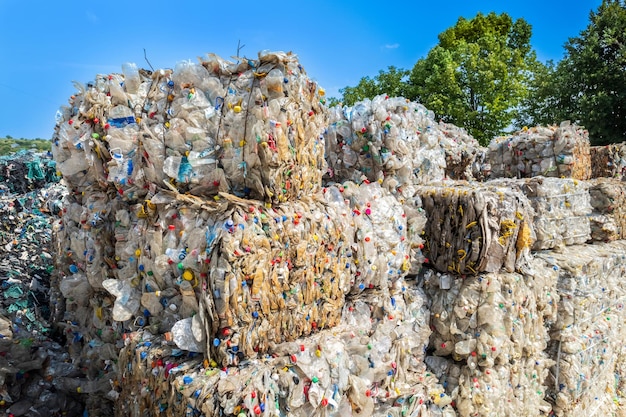 Mehrere würfel aus komprimiertem plastikmüll in der nähe der abfallrecyclingfabrik im freien