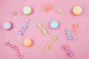 Kostenloses Foto mehrfarbenmakronen mit konfettis auf rosa hintergrund