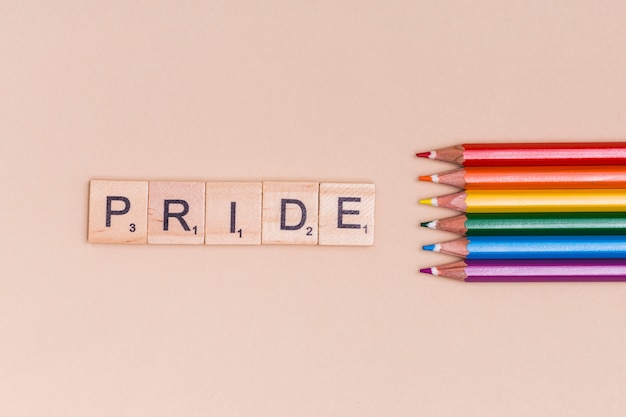 Mehrfarbige Bleistifte und PRIDE-Text auf beige Hintergrund