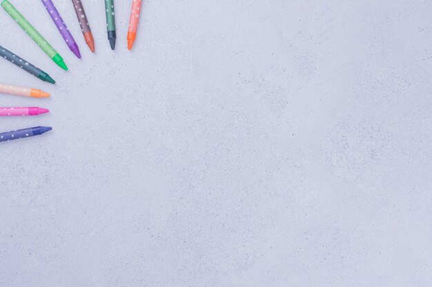 Mehrfarbige Buntstifte zum Basteln oder Malen auf Grau.