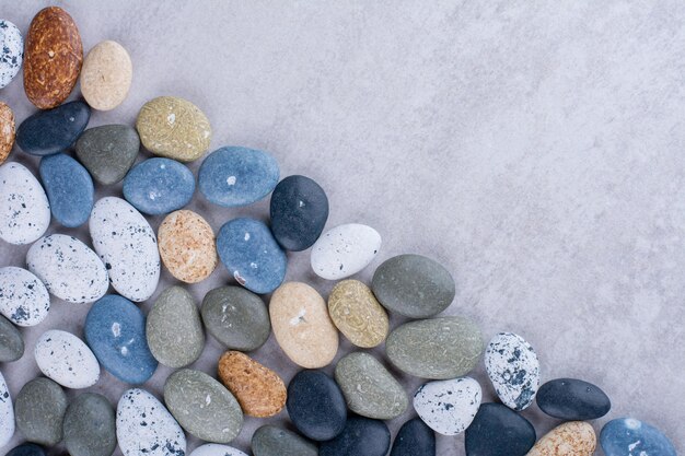 Mehrfarbige dekorative Steine auf konkretem Hintergrund isoliert. Foto in hoher Qualität