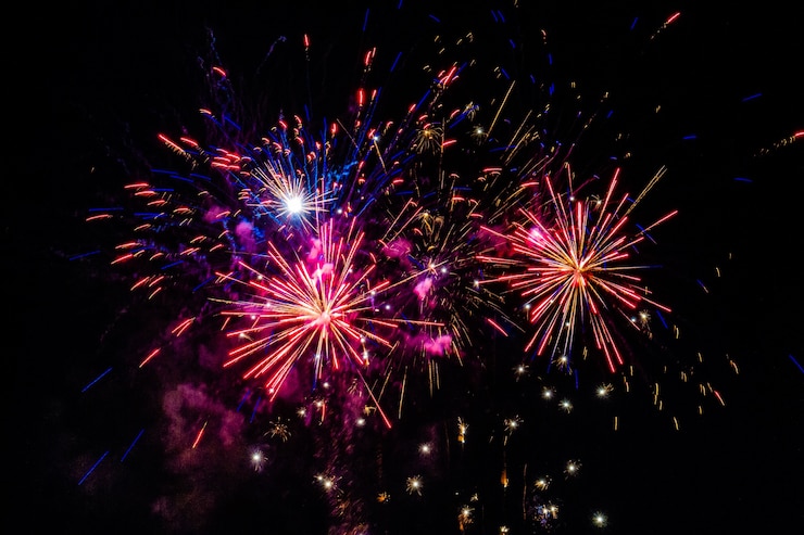 Kostenlose Foto mehrfarbiges feuerwerk, das nachts am himmel explodiert