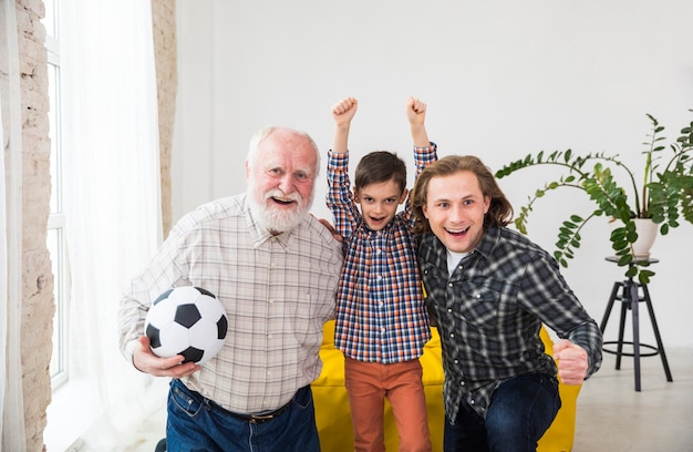 Kostenloses Foto mehrgenerationenmänner, die fernsehen, stützen fußballteam